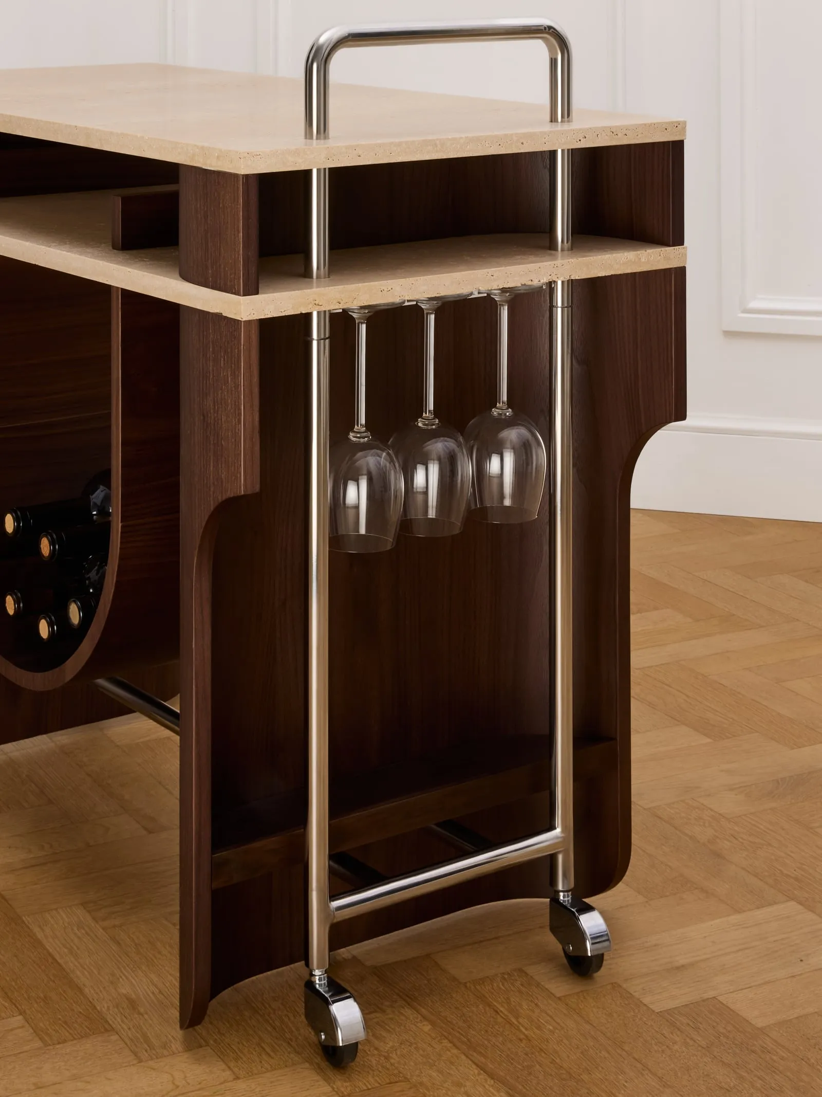 Close view of the Arcus Bar Cart glass rack with wine glasses hanging below the travertine top