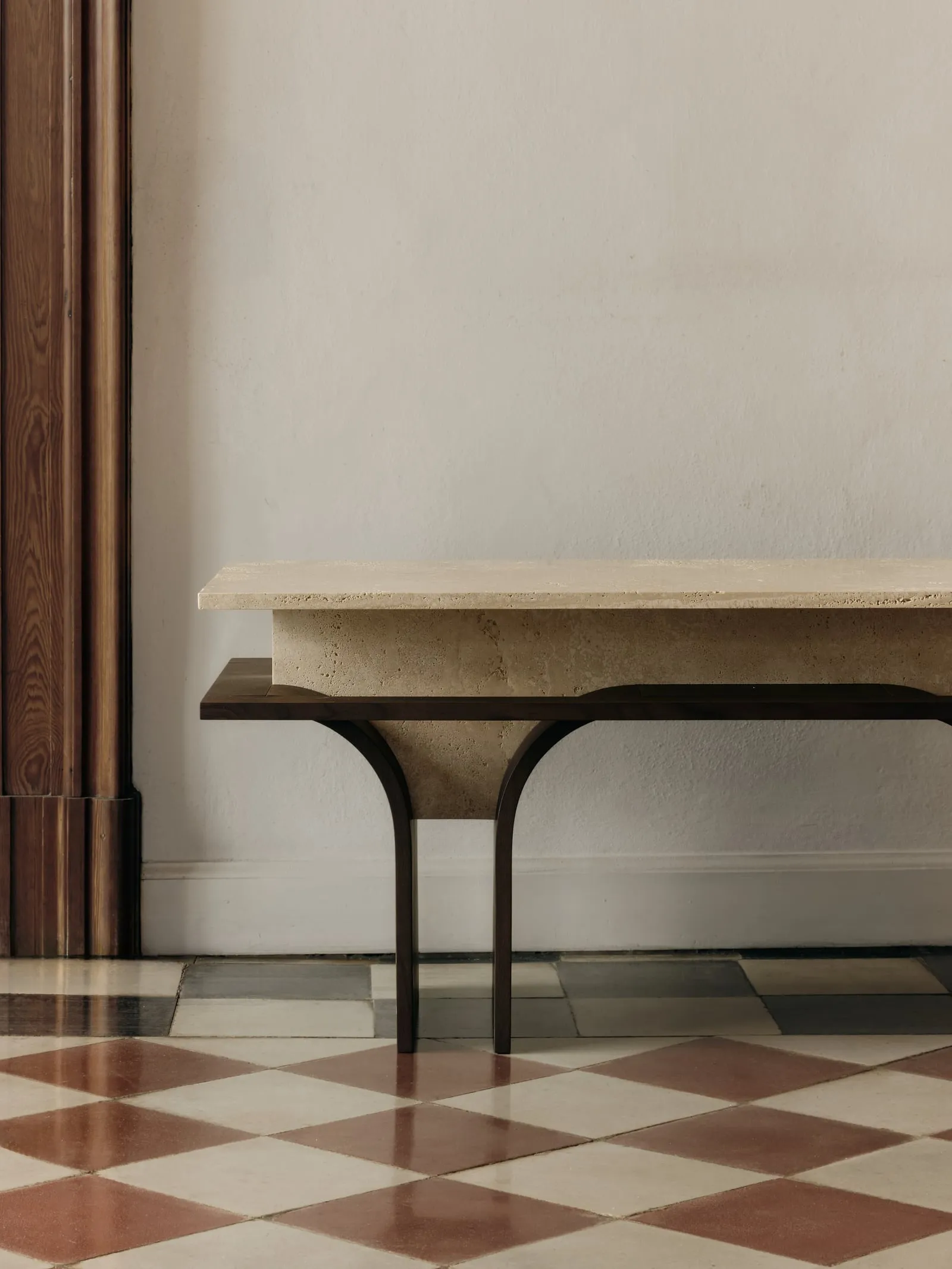 Close view of the Arcus Bench travertine top on its arched wooden support