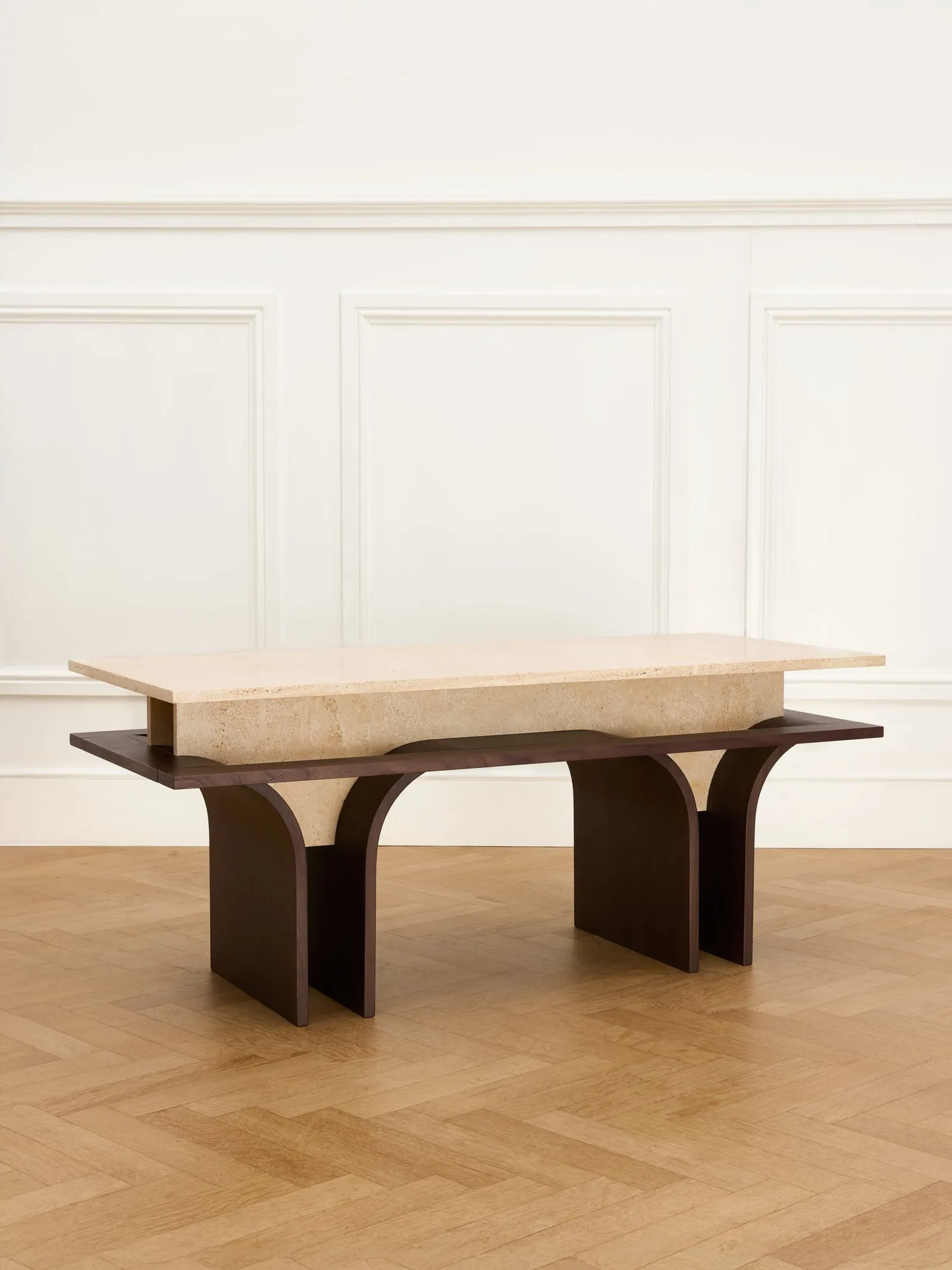 Arcus Bench from a three-quarter angle, travertine top on dark wooden legs