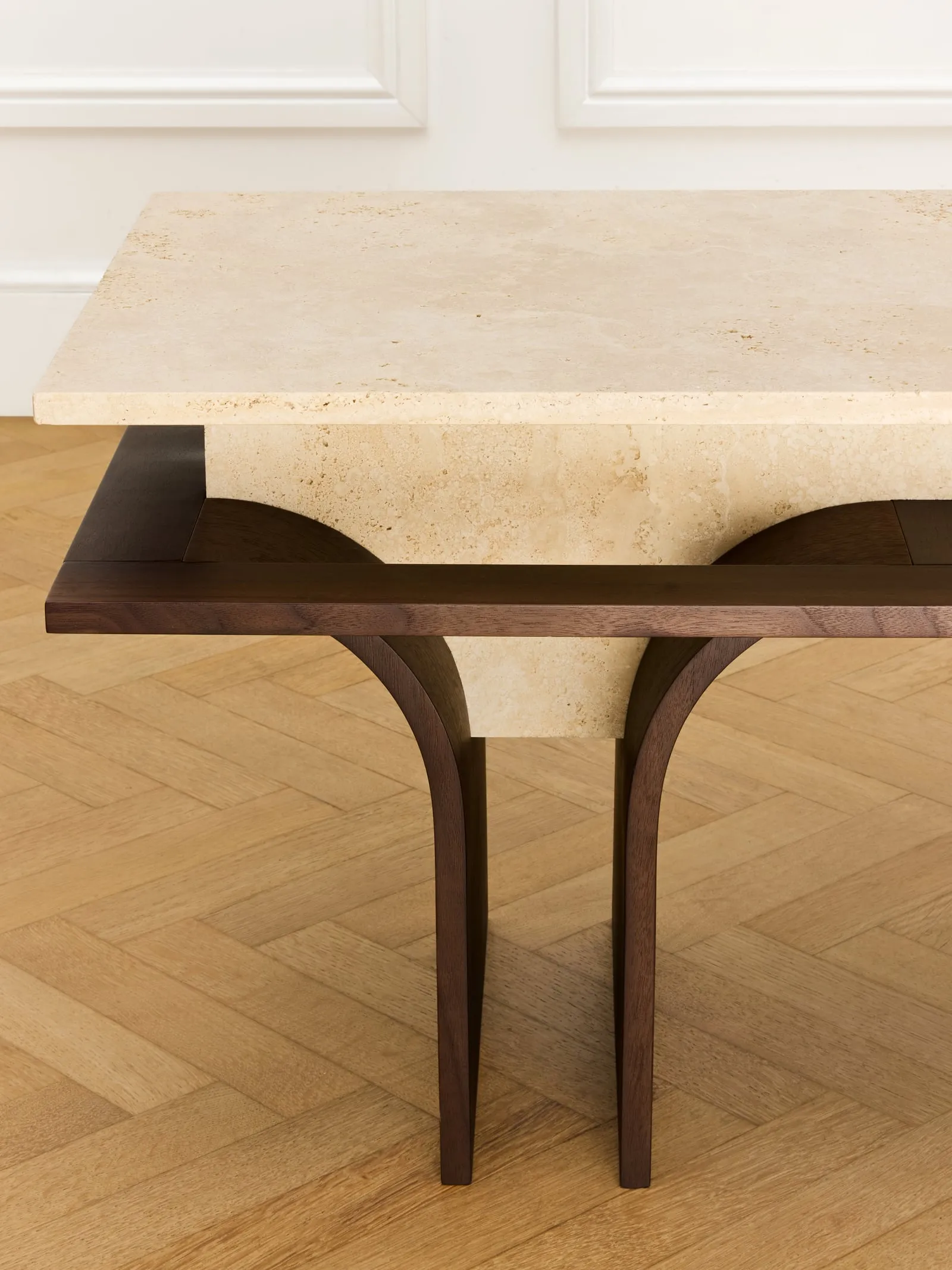 Close view of the Arcus Bench travertine top and curved wooden leg
