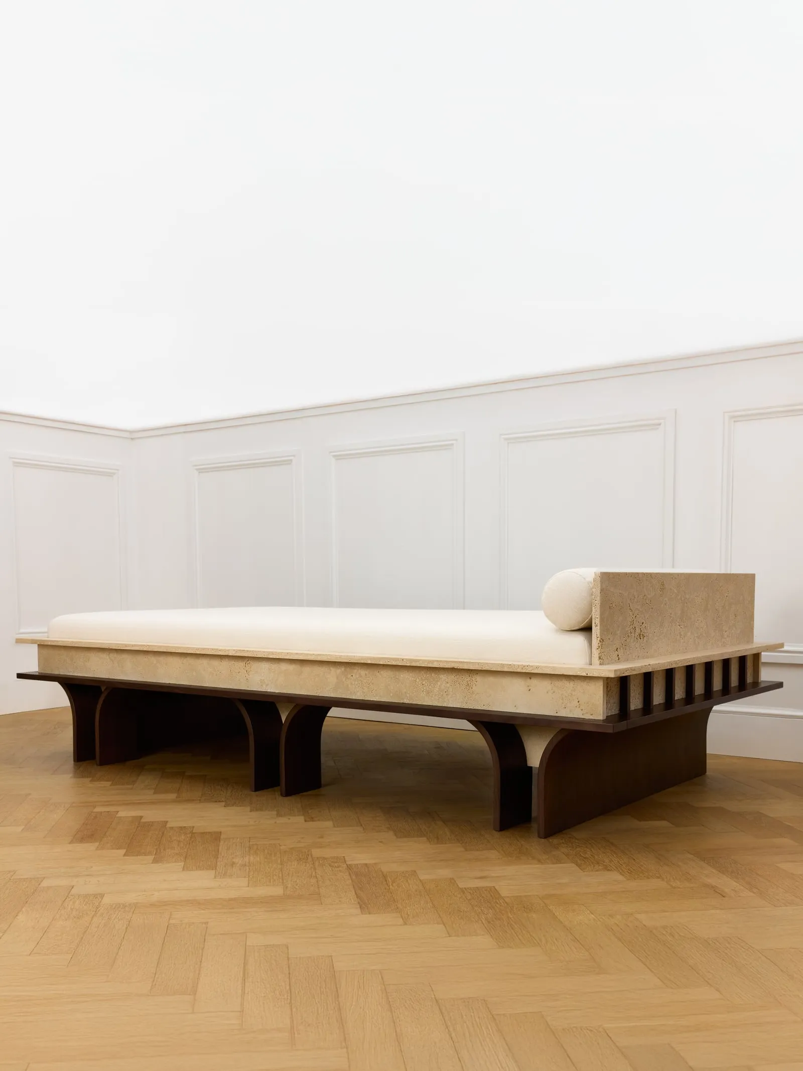 Arcus Daybed from a three-quarter angle, showing the slatted wooden base and bolster