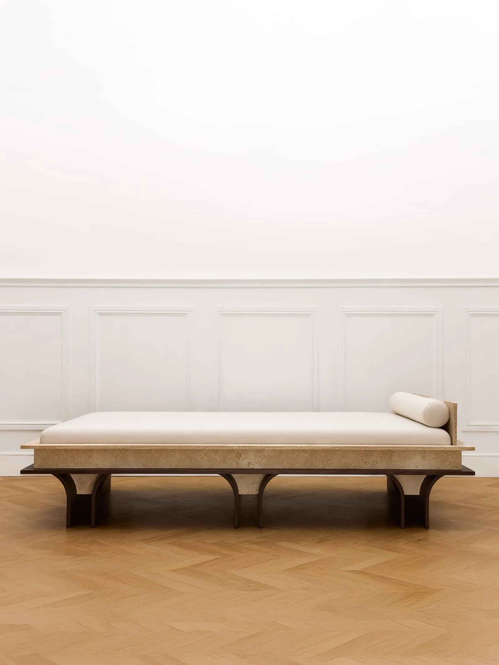 Arcus Daybed from the front in a white panelled room with a parquet floor