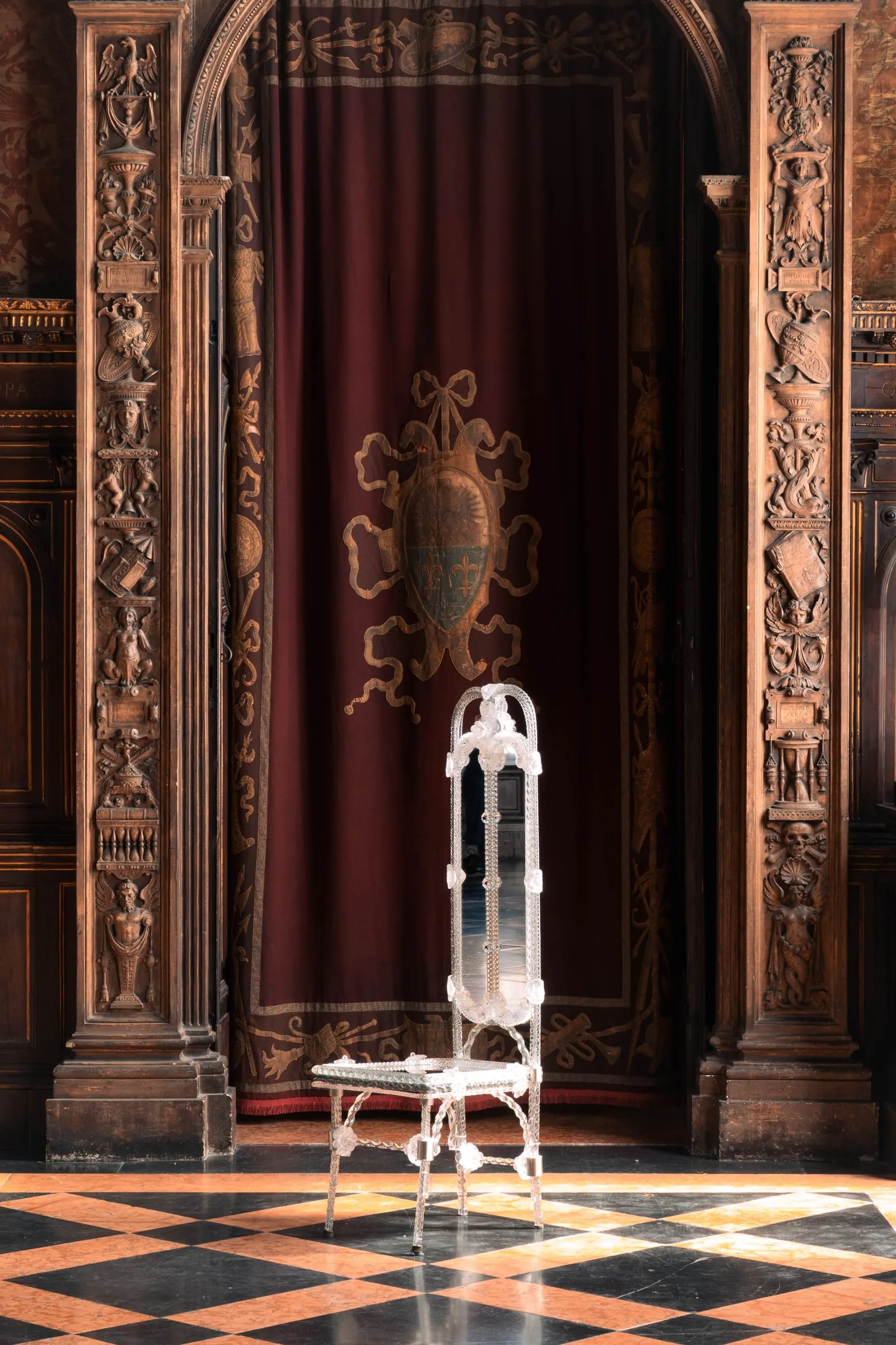 Stemma Dining Chair in a carved wood-panelled hall with a chequered marble floor