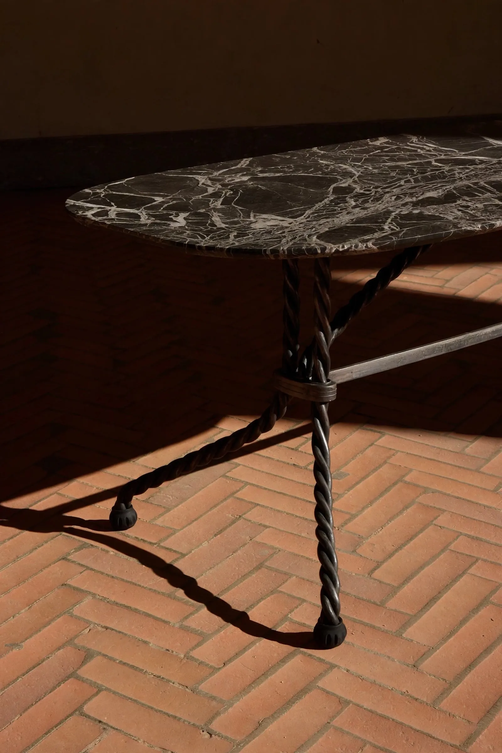 Detail of the Tresse Brasserie Table: veined marble top on braided metal legs