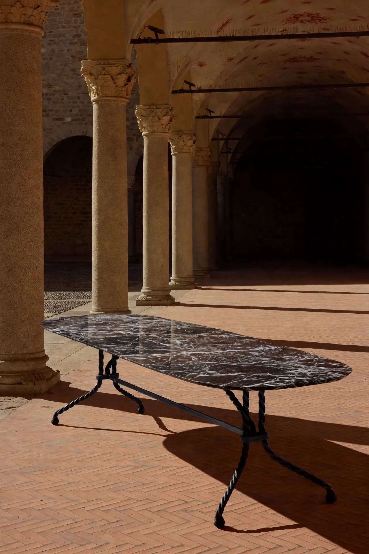 Tresse Brasserie Table between stone columns, casting a long shadow